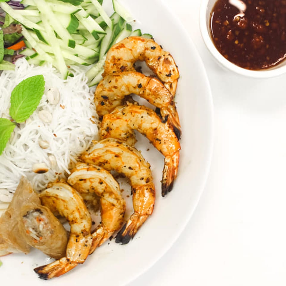 Grilled shrimp, vermicelli noodles, spring roll, and fresh vegetables with dipping sauce.